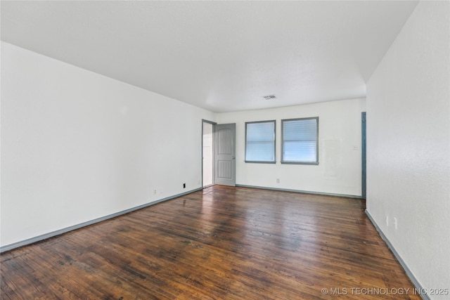 unfurnished room featuring dark hardwood / wood-style flooring