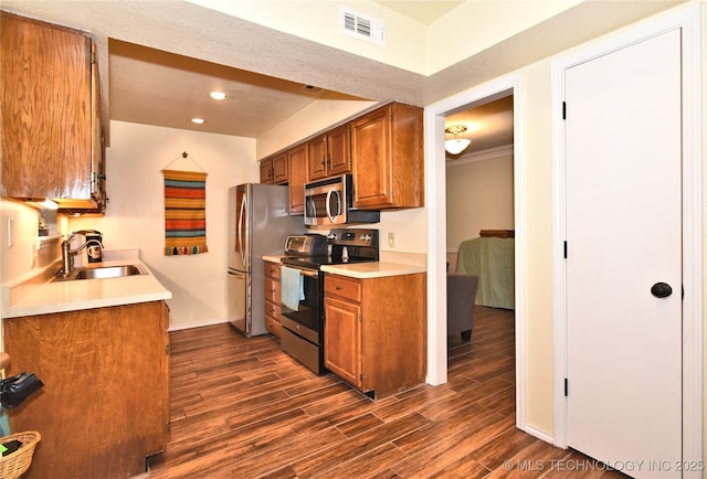 kitchen featuring crown molding, stainless steel appliances, dark hardwood / wood-style floors, and sink