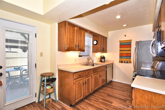 kitchen with sink, dark wood-type flooring, a textured ceiling, and appliances with stainless steel finishes