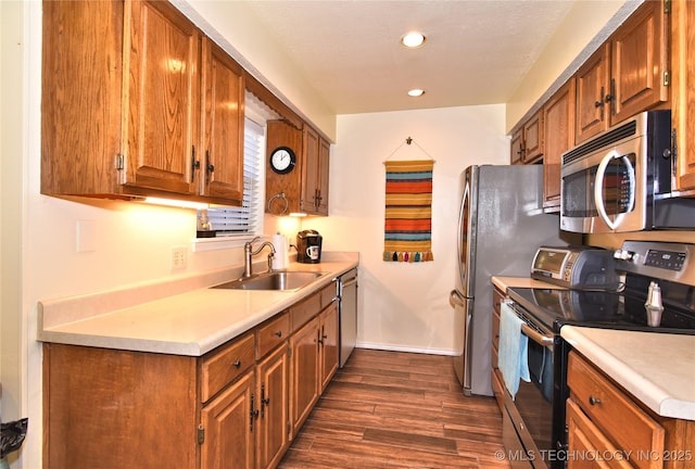 kitchen featuring stainless steel appliances, sink, and dark hardwood / wood-style floors