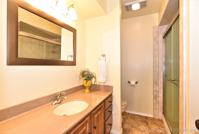 bathroom with toilet, vanity, and walk in shower