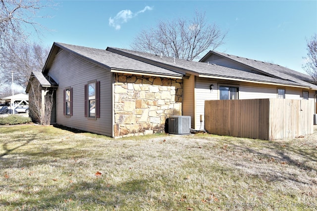 view of side of property with a yard and central air condition unit