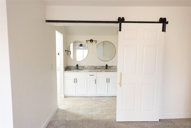 full bathroom featuring double vanity, a sink, and baseboards