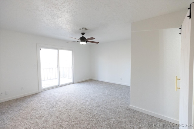 unfurnished room with ceiling fan, carpet floors, and a textured ceiling