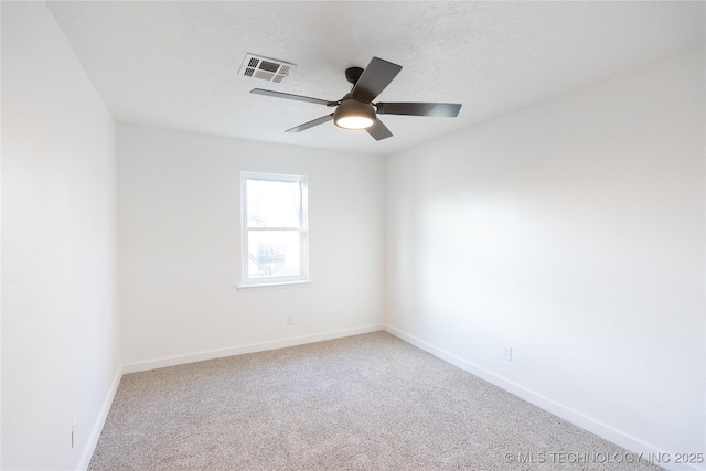 carpeted spare room featuring ceiling fan and a textured ceiling