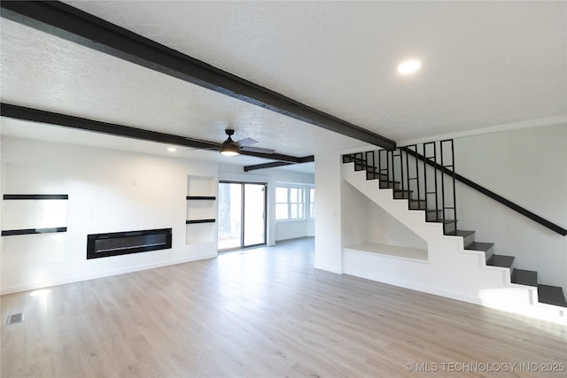 7850 S Park Ave, Broken Arrow, OK 74011 - unfurnished living room featuring wood finished floors, beamed ceiling, baseboards, stairs, and ceiling fan