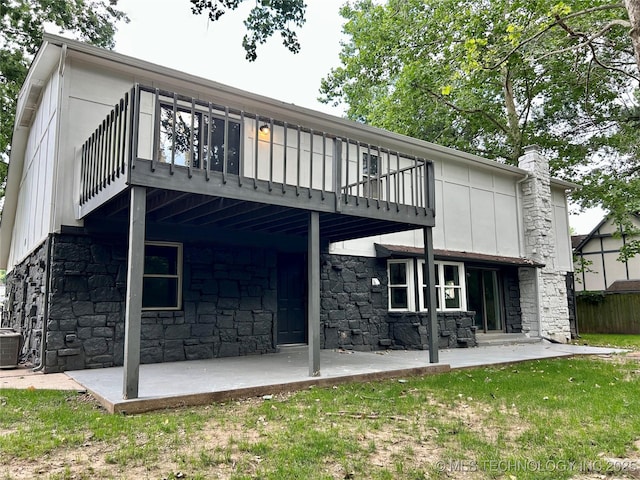 7850 S Park Ave, Broken Arrow, OK 74011 - rear view of property with a patio, stone siding, central AC unit, a chimney, and a balcony