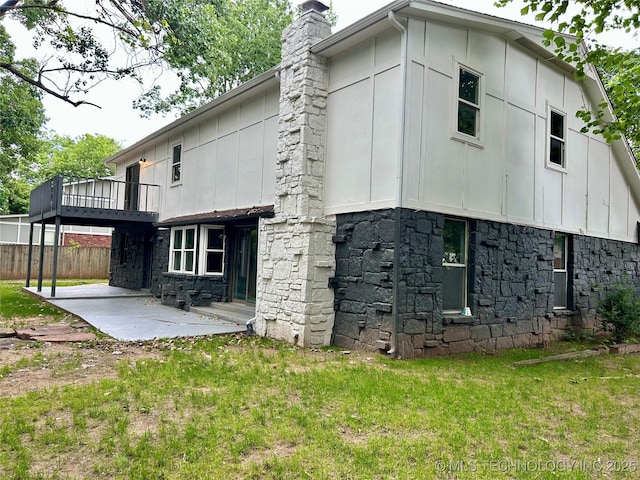 7850 S Park Ave, Broken Arrow, OK 74011 - view of side of home with stone siding, a patio, board and batten siding, and a chimney