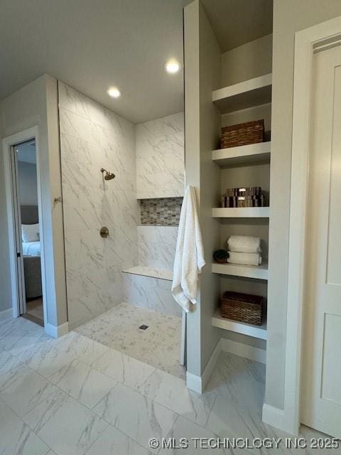 bathroom featuring built in shelves and tiled shower