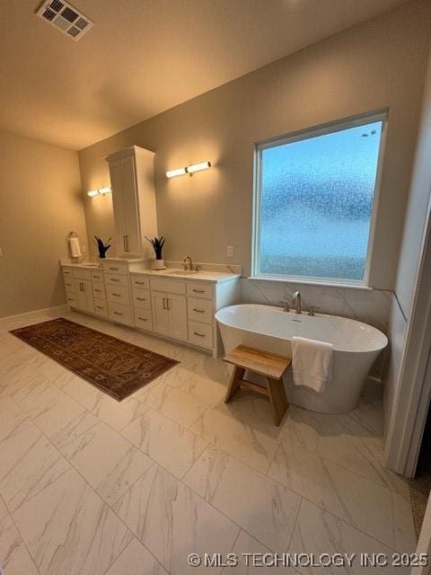 bathroom featuring vanity and a tub