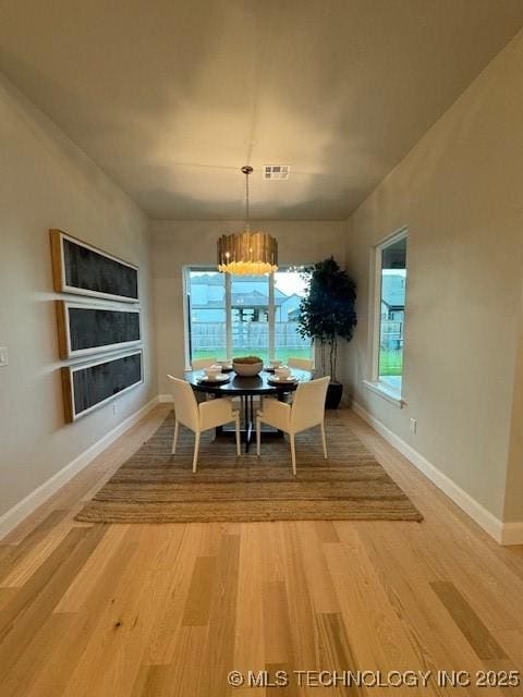 dining room with hardwood / wood-style flooring and a chandelier