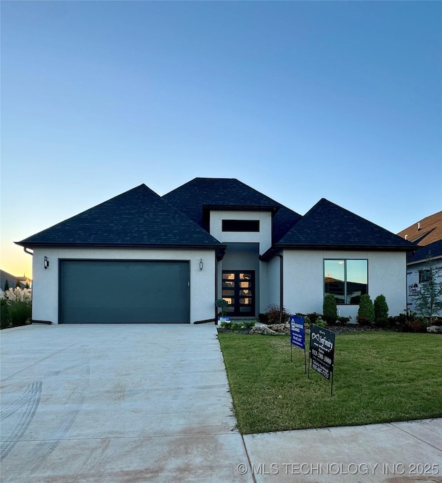 prairie-style house with a yard and a garage