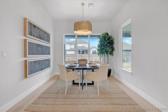 dining area with a chandelier and light hardwood / wood-style floors