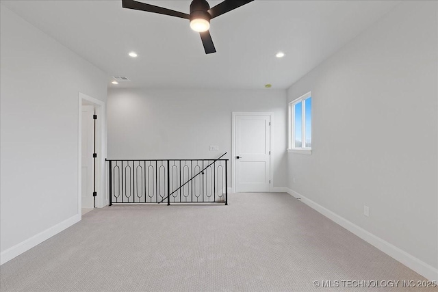 carpeted spare room featuring ceiling fan