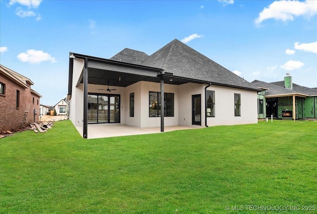 rear view of property featuring a patio, ceiling fan, and a lawn