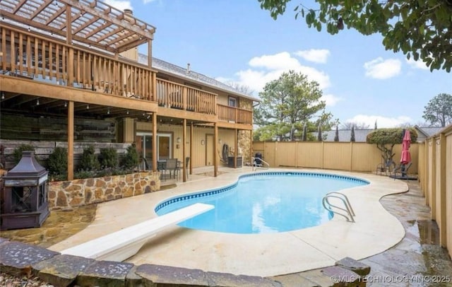 view of pool featuring a diving board and a patio area