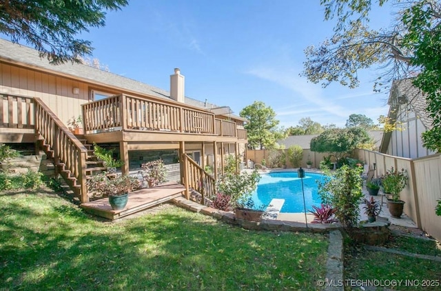 view of pool with a yard, a diving board, and a deck