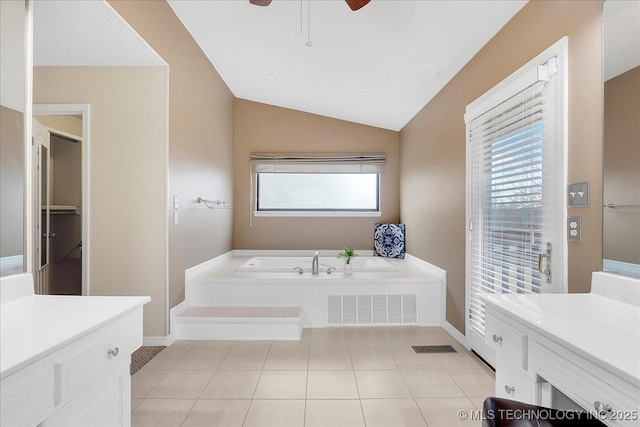 bathroom featuring lofted ceiling, tile patterned floors, ceiling fan, and a tub to relax in