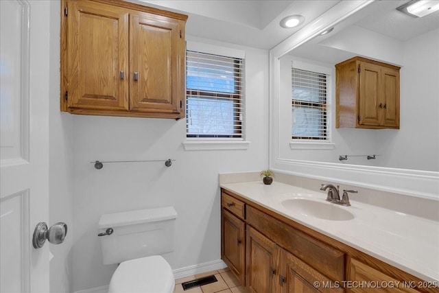 bathroom with tile patterned flooring, vanity, and toilet