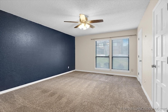 unfurnished room with ceiling fan, carpet, and a textured ceiling