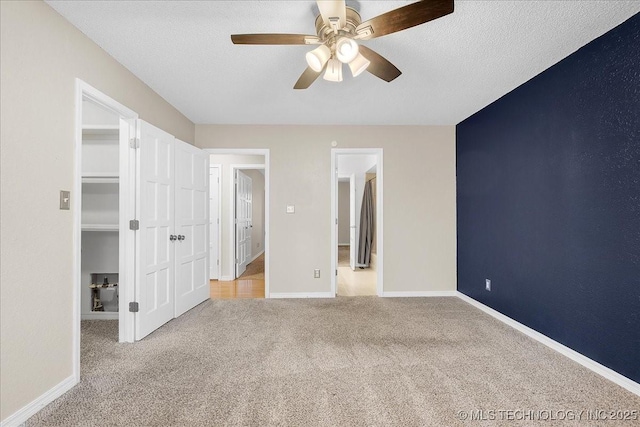 unfurnished bedroom featuring ceiling fan, light colored carpet, and a textured ceiling