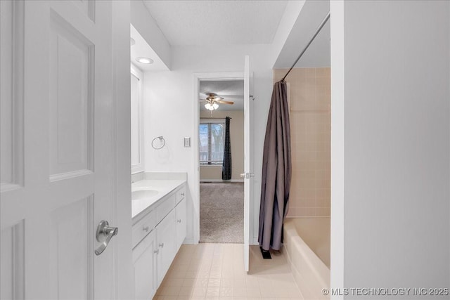 bathroom featuring tile patterned floors, a textured ceiling, vanity, shower / bathtub combination with curtain, and ceiling fan