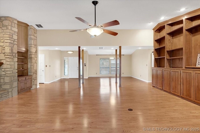 unfurnished living room featuring built in shelves, light hardwood / wood-style flooring, and ceiling fan