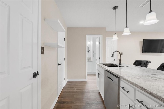 kitchen with pendant lighting, sink, white cabinets, stainless steel dishwasher, and light stone countertops