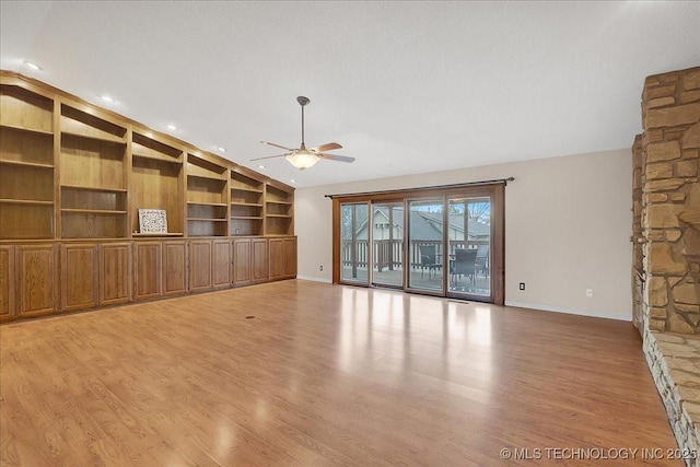 unfurnished living room featuring vaulted ceiling, built in shelves, ceiling fan, and light hardwood / wood-style flooring