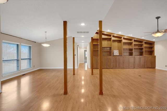 interior space featuring ceiling fan, light hardwood / wood-style floors, and built in shelves