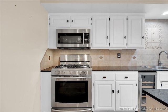 kitchen with wine cooler, sink, stainless steel appliances, and white cabinets