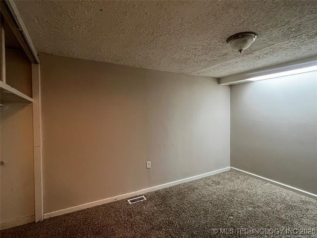 spare room featuring a textured ceiling and carpet flooring