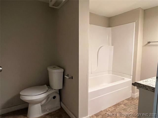 full bathroom featuring washtub / shower combination, vanity, and toilet