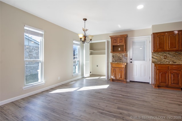 unfurnished dining area with hardwood / wood-style flooring and a chandelier