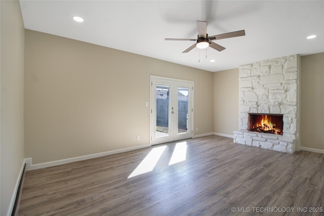 unfurnished living room with french doors, ceiling fan, a fireplace, and dark hardwood / wood-style flooring