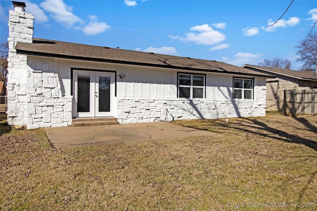 back of property with a yard, a patio area, and french doors