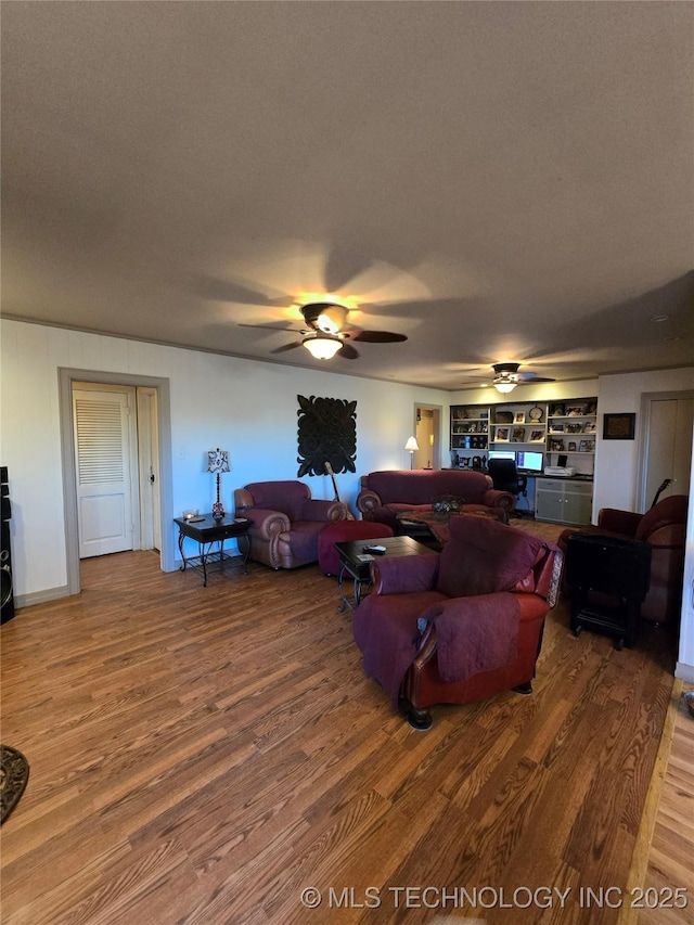 living room featuring hardwood / wood-style flooring, ceiling fan, and a textured ceiling