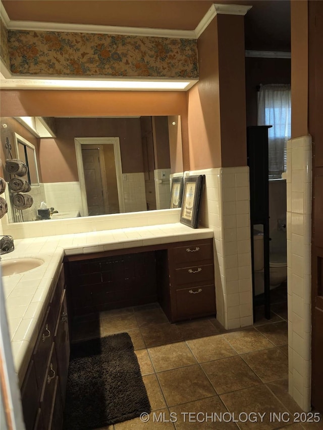 bathroom with tile walls, ornamental molding, vanity, toilet, and tile patterned floors