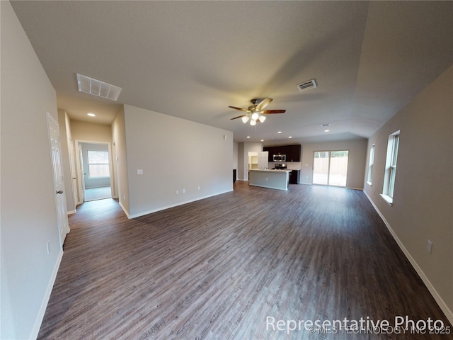 unfurnished living room with dark wood-type flooring and ceiling fan