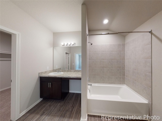 bathroom with bathing tub / shower combination, wood-type flooring, and vanity