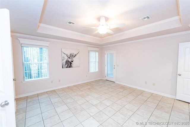 spare room with ceiling fan, a tray ceiling, and a healthy amount of sunlight