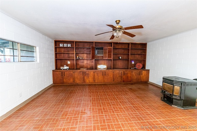 interior space featuring ceiling fan and a wood stove