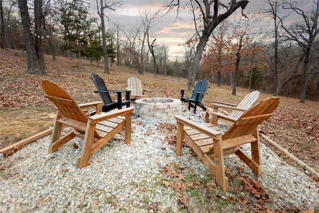 patio terrace at dusk featuring an outdoor fire pit