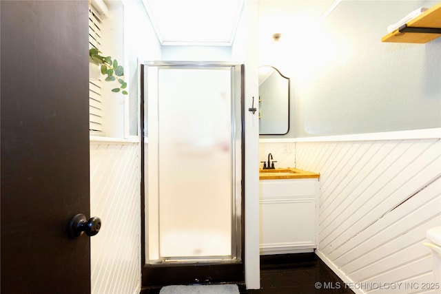 bathroom featuring vanity, wood walls, and walk in shower