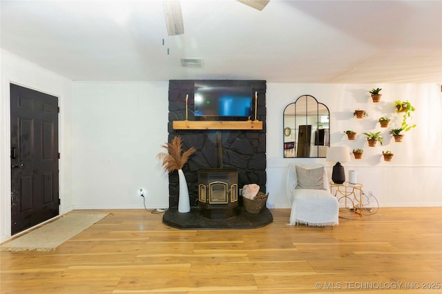 living room with wood-type flooring and a wood stove