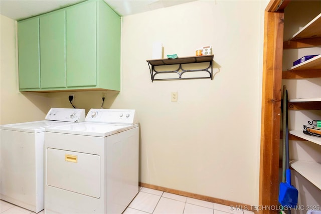 laundry area with cabinets, washing machine and dryer, and light tile patterned floors