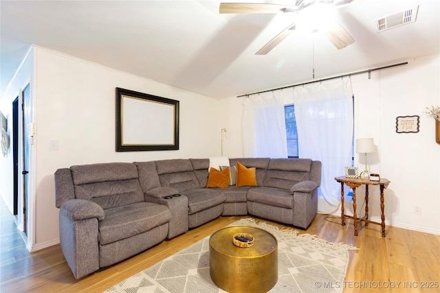 living room featuring wood-type flooring and ceiling fan