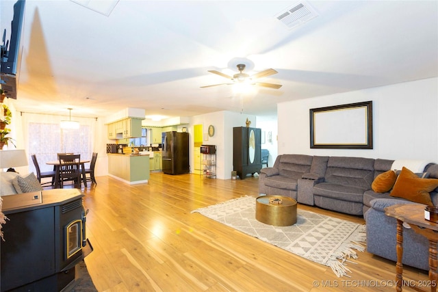 living room with light hardwood / wood-style floors and ceiling fan