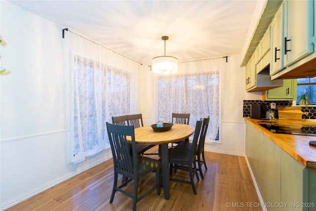 dining space with light hardwood / wood-style floors and a notable chandelier