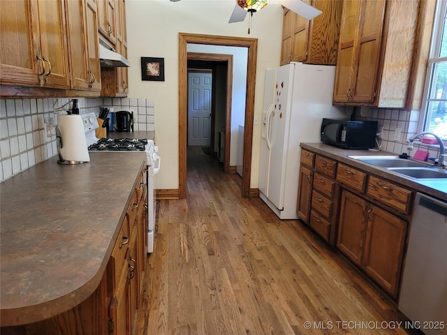 kitchen with sink, tasteful backsplash, ceiling fan, white appliances, and hardwood / wood-style floors